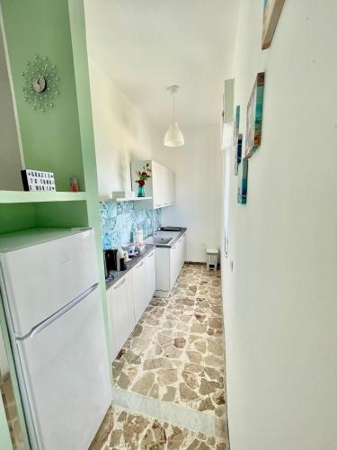 a kitchen with green walls and a white refrigerator at Acquamarina B&B Deluxe in Cariati