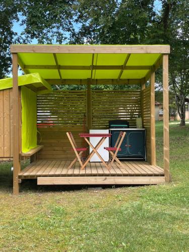 - un kiosque avec une table et des chaises sur une terrasse dans l'établissement Camping le Convivial Cop'Camp 2 personnes, à Saint-Martial-de-Nabirat