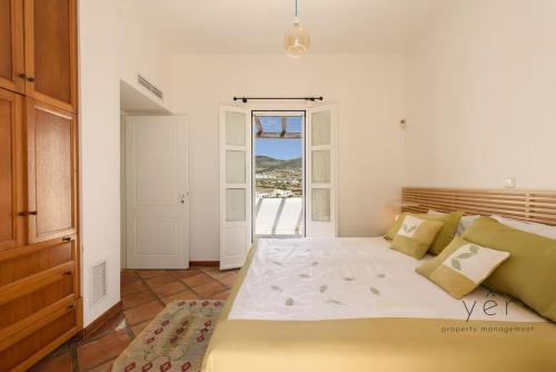 a bedroom with a large bed and a door to a balcony at 6BR Villa with Private Pool, 4 Baths & Garden -PADMA in Angairiá
