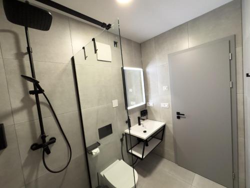 a bathroom with a shower and a toilet and a sink at ROCH800 - industriální aparthotel Klatovy in Klatovy