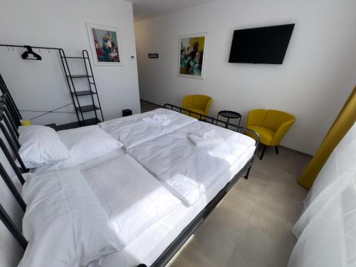 a bedroom with two beds and a flat screen tv at ROCH800 - industriální aparthotel Klatovy in Klatovy