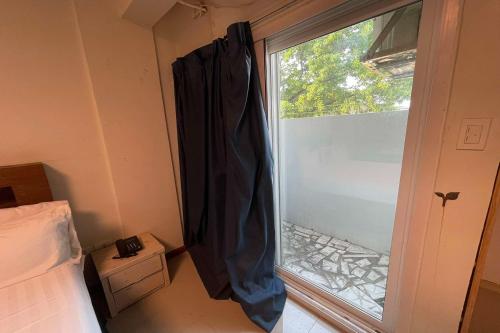 a bedroom with a window with a curtain next to it at Aimor Condotel in Pampang