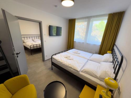 a bedroom with a bed and a chair and a mirror at ROCH800 - industriální aparthotel Klatovy in Klatovy