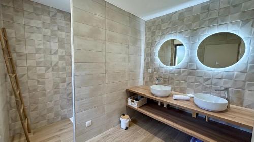 une salle de bain avec deux lavabos et deux miroirs dans l'établissement Dame Jeanne Maison de 10 personnes avec jardin et parking, au Crotoy