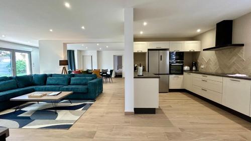 un salon avec un canapé bleu et une cuisine dans l'établissement Dame Jeanne Maison de 10 personnes avec jardin et parking, au Crotoy