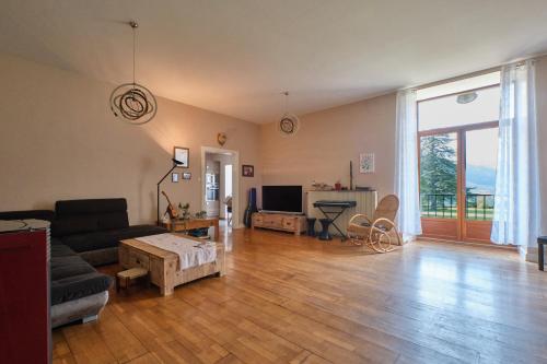 un salon avec un canapé et une table dans l'établissement Suite Marguerite chez l'habitant, à Saint-Geoire-en-Valdaine