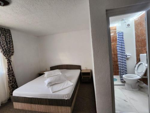 a bedroom with a bed and a bathroom with a toilet at Casa Daria in Costinesti