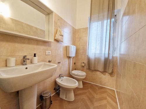 a white bathroom with a sink and a toilet at La Ca' di sogn in Pavia