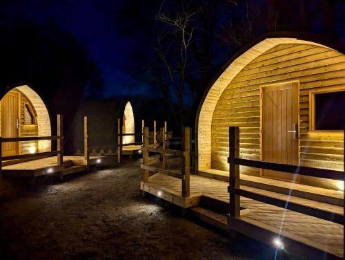 a wooden cabin with a wooden door and a fence at Forrester Park Glamping Pods - Eagle Pod and Birdie Pods in Great Totham