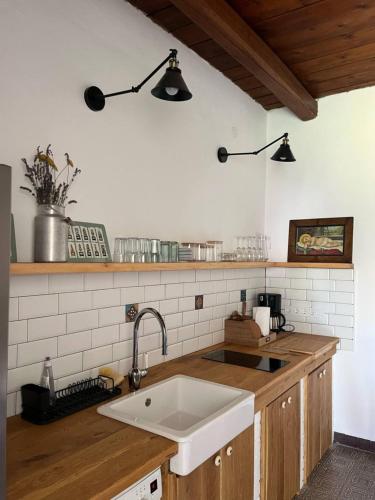 a kitchen with a sink and two lights on the wall at Lelle Cottage in Balatonlelle