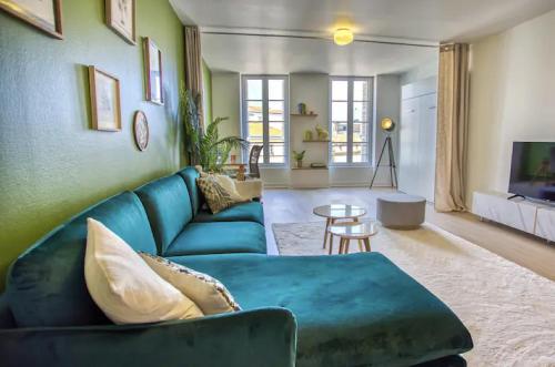 un salon avec un canapé bleu et une table dans l'établissement La suite végétale, spacieuse et hyper centre, à Angoulême