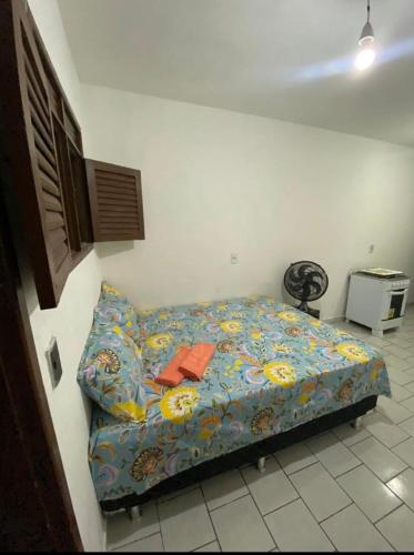a bedroom with a bed with a colorful blanket at kitnet bem localizado in João Pessoa