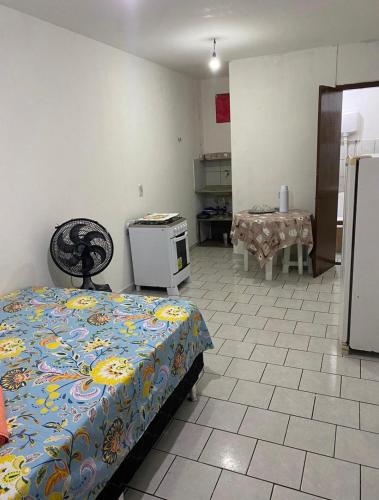 a room with a bed and a kitchen with a stove at kitnet bem localizado in João Pessoa