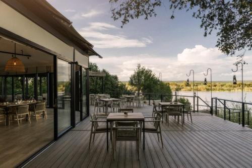 un ristorante con tavoli e sedie su un ponte di Zambezi Sands by Batoka a Victoria Falls