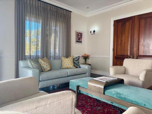 a living room with a couch and chairs and a table at Lemoenkloof Boutique Hotel in Paarl