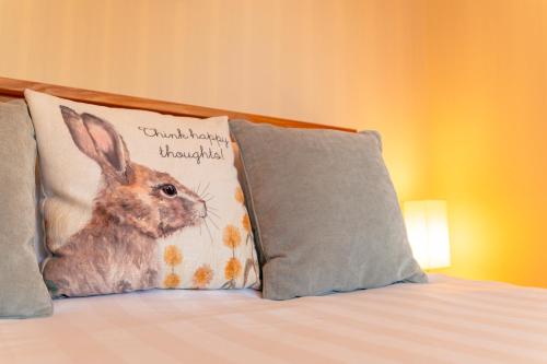 a pillow with a rabbit on it sitting on a bed at The Stables in Firsby