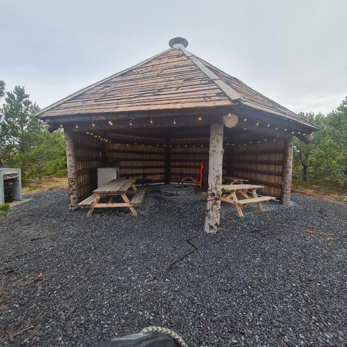 a large wooden cabin with picnic tables in it at MB Guesthouse in Grímsnes og Grafningshreppur