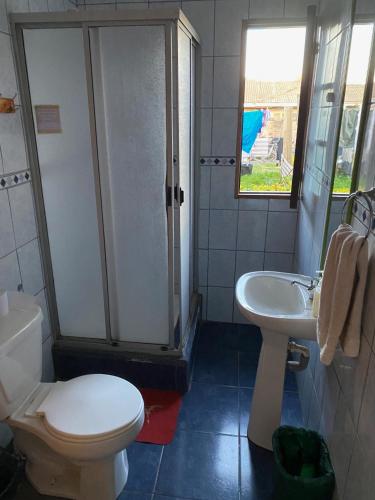 a bathroom with a toilet and a sink at Hostal Kuyen in Pichilemu