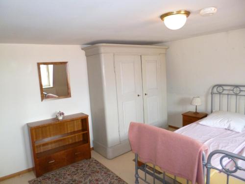 une chambre avec un lit, un miroir et une chaise dans l'établissement Roaringtwenties, à La Celle-sous-Gouzon