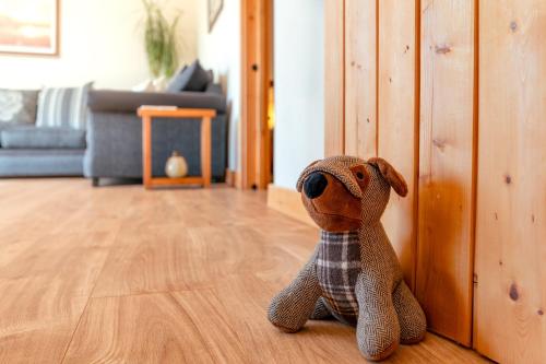 a stuffed dog sitting on the floor in a living room at The Stables in Firsby