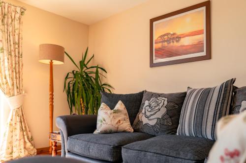 a living room with a gray couch with pillows at The Stables in Firsby