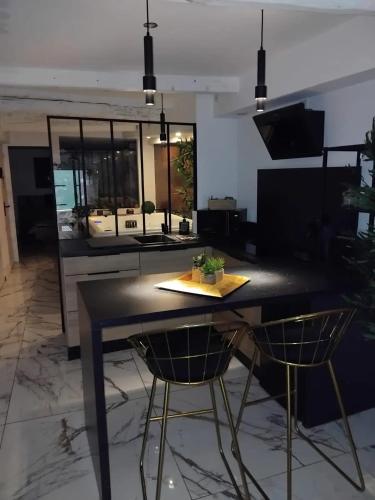 une cuisine avec une table noire et deux chaises dans l'établissement Appartement charmant à Pignans - 46 m² avec jacuzzi, à Pignans