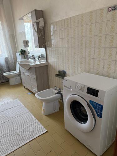 a bathroom with a washing machine and a toilet at Affittacamere La CRICOVA di Iulia in Cervasca