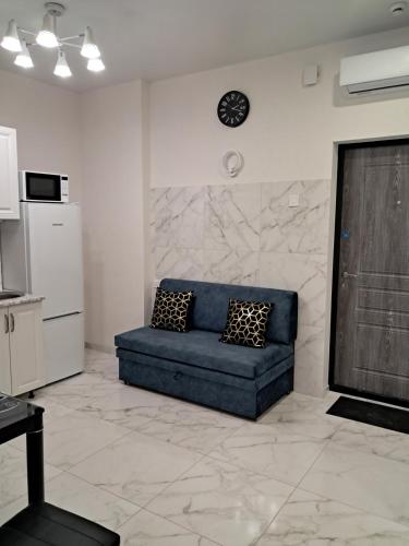a living room with a blue couch and a clock on the wall at АРКАДИЯ ОДЕССА Новые апартаменты ЖК Родос Black Sea in Odesa