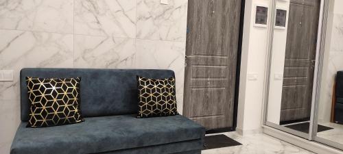 a blue couch with two pillows in a room at АРКАДИЯ ОДЕССА Новые апартаменты ЖК Родос Black Sea in Odesa