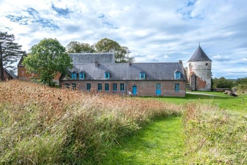 an old building with a tower on a field at Auberge de jeunesse-La Hulotte in Montreuil-sur-Mer