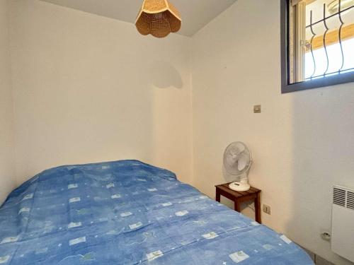 - une chambre avec un lit, un ventilateur et une fenêtre dans l'établissement Studio cabine 4 pers, piscine, parking privé, proche plage - Argelès-sur-Mer - FR-1-225-602, à Argelès-sur-Mer