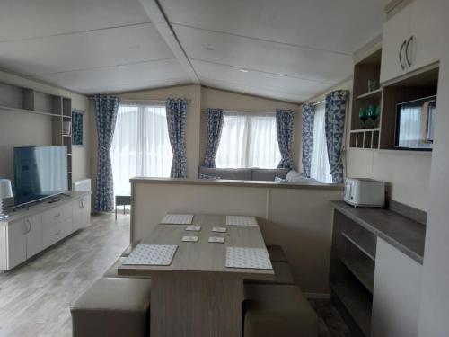 a living room with a table and a kitchen at 33 Unity Beach Pet friendly Pets stay free 3 bedrooms sleeps 8 in Brean