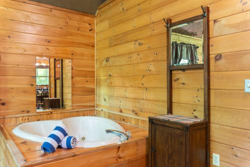 a bath tub in a room with wooden walls at Passion Pointe Getaway in Sevierville