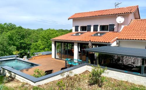 une maison avec une terrasse et une piscine dans l'établissement Maison de campagne au calme avec piscine, à Labruguière