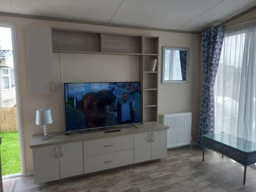 a living room with a flat screen tv on a wall at 33 Unity Beach Pet friendly Pets stay free 3 bedrooms sleeps 8 in Brean