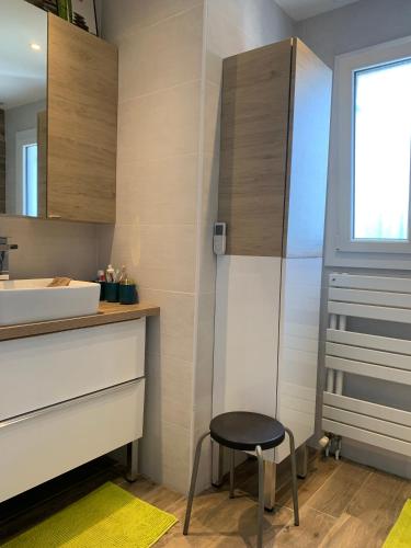 une petite salle de bain avec un lavabo et un tabouret dans l'établissement Maison de campagne au calme avec piscine, à Labruguière