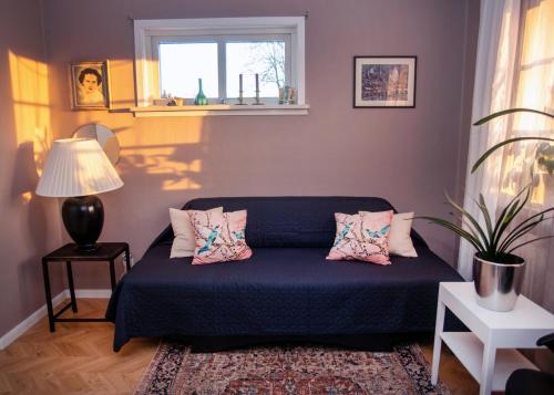 a bedroom with a blue bed with pillows and a window at Bubo mysigt litet hus i Noret in Mora
