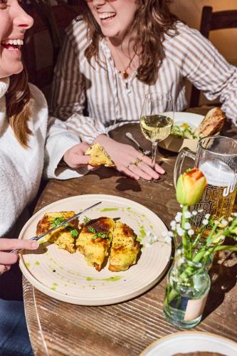 two women sitting at a table with a plate of food at The Chequers Inn, Thornham in Thornham