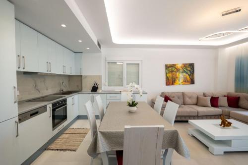 a kitchen and living room with a table and a couch at Luxury Sea View Apartments in Sarandë