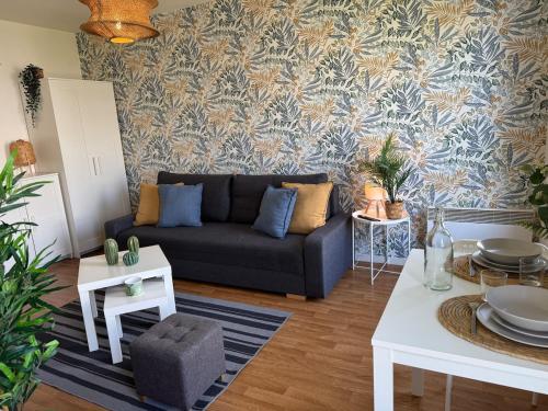 un salon avec un canapé et une table dans l'établissement ღ Jumanji - Proche Parc et Commodités & Wifi, à Sainte-Luce-sur-Loire