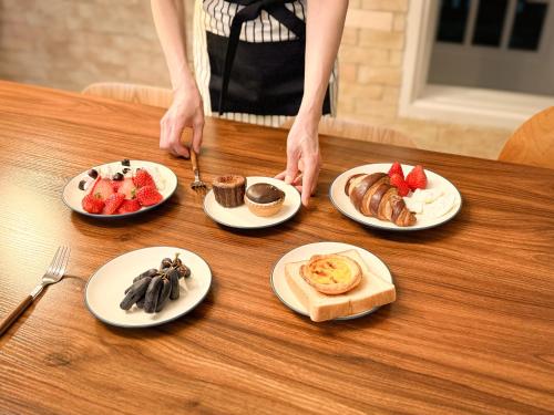 a woman standing at a table with plates of breakfast foods at Won stay in Osan