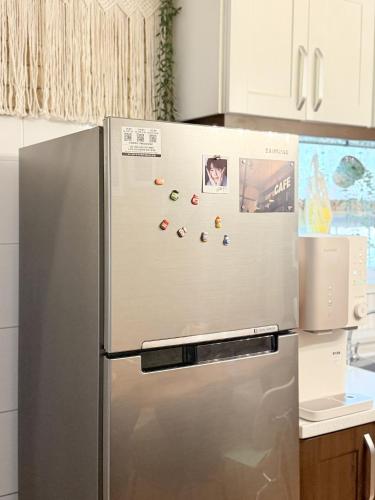 a refrigerator in a kitchen with magnets on it at Won stay in Osan