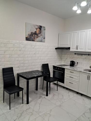 a kitchen with a table and two chairs and a stove at АРКАДИЯ ОДЕССА Новые апартаменты ЖК Родос Black Sea in Odesa