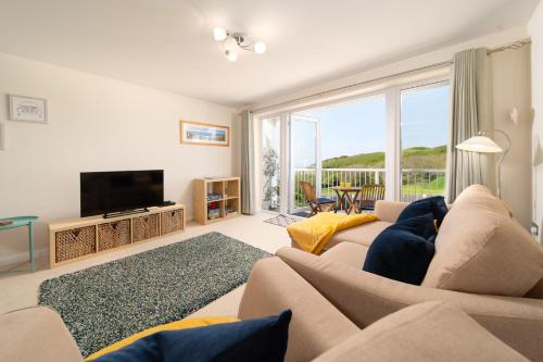 a living room with a couch and a television at 6 Bluestone Point in Mortehoe