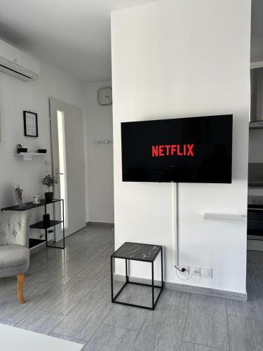 a living room with a television on a wall at Appartement t2 avec terrasse et cour in Cavaillon