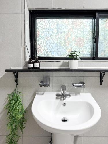 a white sink in a bathroom with a window at Won stay in Osan