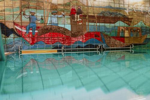 a painting of a boat in a swimming pool at Hotel das Miramar in Borkum