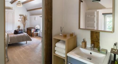 une salle de bain avec un lavabo et une chambre avec un lit dans l'établissement La Cour Souveraine - Chambre d'hôtes Le Cap, à Mosles