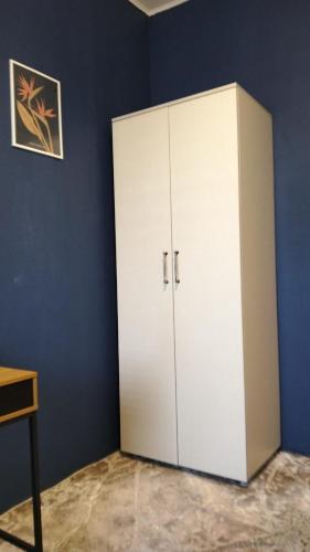 un armario blanco en una habitación con una pared azul en Hotel Safir Babice, en Babice Nowe