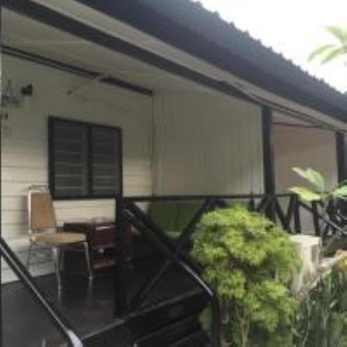 a balcony with a desk and a chair on a house at Nipah Bay Villa in Pangkor